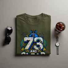 Load image into Gallery viewer, Olive green t-shirt with "73 AND" graphic featuring a globe and radio equipment.
