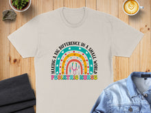 Load image into Gallery viewer, Beige t-shirt with rainbow design for pediatric nurse.
