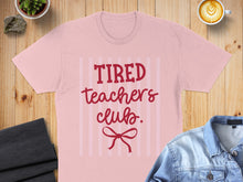 Load image into Gallery viewer, Pink t-shirt with "Tired Teachers Club" text and a red bow graphic.
