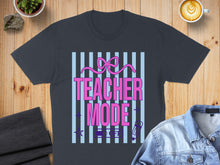 Load image into Gallery viewer, Teacher Mode graphic on a dark t-shirt with pink bow and blue stripes.
