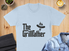 Load image into Gallery viewer, Light blue t-shirt with "The Grillfather" text and sausage on a fork.
