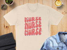 Load image into Gallery viewer, Cream t-shirt with pink "Nurse Nurse" text and floral accents.

