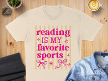 Load image into Gallery viewer, T-shirt with pink text "Reading is my favorite sports" and decorative bows.
