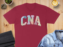 Load image into Gallery viewer, Maroon t-shirt with "CNA" spelled out in colorful patchwork letters.
