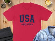 Load image into Gallery viewer, Red t-shirt with "USA EST. 1776" in blue lettering.
