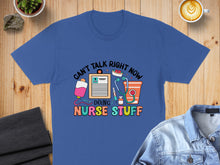 Load image into Gallery viewer, Blue t-shirt with "Can't Talk Right Now Doing Nurse Stuff" and medical icons.

