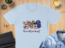 Load image into Gallery viewer, Light blue t-shirt with peace sign, heart, and EMT emblem with text.
