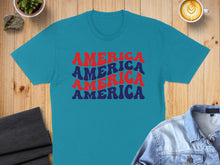 Load image into Gallery viewer, Teal t-shirt with "AMERICA" repeated in red and blue retro font.
