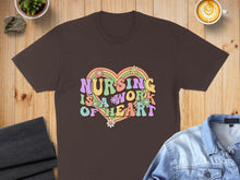 Load image into Gallery viewer, Brown t-shirt with "Nursing is a work of heart" in colorful retro lettering.
