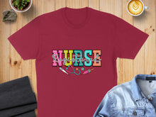 Load image into Gallery viewer, Burgundy t-shirt with colorful "NURSE" text and medical graphic.
