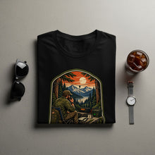 Load image into Gallery viewer, Black t-shirt with graphic of man on radio in mountains at sunset.
