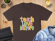 Load image into Gallery viewer, Brown t-shirt with "Teach Love Inspire" text in colorful, retro font.
