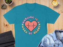 Load image into Gallery viewer, Teal t-shirt with "Nursing is a work of heart" text and electrocardiogram graphic.
