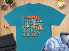 Load image into Gallery viewer, Teal t-shirt with "Educated. Caffeinated. Dedicated. Hospice Nurse." text in colorful retro font.
