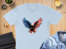 Load image into Gallery viewer, Light blue t-shirt with a bald eagle graphic in patriotic American flag colors.
