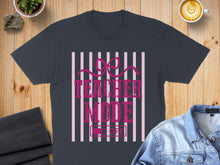 Load image into Gallery viewer, Dark t-shirt with "Teacher Mode" text and a pink bow, set against striped background.
