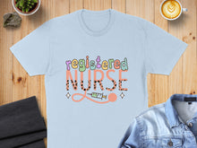 Load image into Gallery viewer, Light blue t-shirt with colorful "Registered Nurse" text and a syringe graphic.
