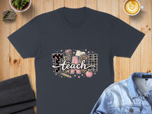 Load image into Gallery viewer, Dark grey t-shirt with "Teach" graphic featuring leopard print, plaid, and school supplies.
