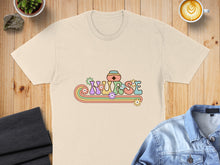 Load image into Gallery viewer, Cream t-shirt with retro "Nurse" text design featuring flowers and rainbows.
