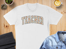 Load image into Gallery viewer, White t-shirt with "TEACHER" spelled out in a floral pattern.
