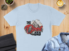Load image into Gallery viewer, Light blue t-shirt with "The Cool Dad" text and mountain graphic.

