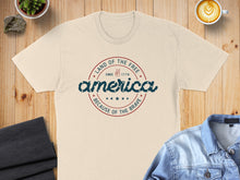 Load image into Gallery viewer, Cream t-shirt with "America Land of the Free Since 1776 Because of the Brave" graphic.
