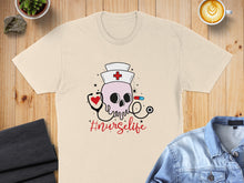 Load image into Gallery viewer, Nurse skull graphic with stethoscope and #nurseiife text on a cream t-shirt.
