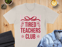 Load image into Gallery viewer, Tired Teachers Club graphic tee with pencils, bows, and stars.
