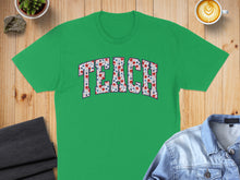Load image into Gallery viewer, Green t-shirt with "TEACH" spelled out in colorful floral pattern.
