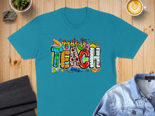 Load image into Gallery viewer, Teal t-shirt with "made to TEACH" text in colorful, school-themed letters.
