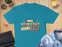 Load image into Gallery viewer, Teal t-shirt with "NURSING IS IN MY DNA" text and syringe illustration.

