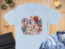 Load image into Gallery viewer, Light blue t-shirt with "USA" text art featuring American flag and floral design.

