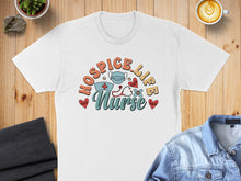 Load image into Gallery viewer, White t-shirt with "Hospice Nurse" graphic, stethoscope, hearts, and mask.
