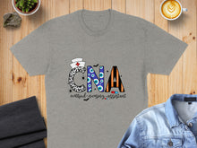 Load image into Gallery viewer, Gray t-shirt with "CNA Certified Nursing Assistant" text and Halloween-themed designs.
