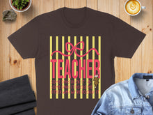 Load image into Gallery viewer, Dark brown t-shirt with "TEACHER" and inspirational quotes, set against a wood background.
