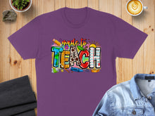 Load image into Gallery viewer, Purple t-shirt with "made to TEACH" in colorful, playful lettering.

