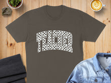 Load image into Gallery viewer, Brown t-shirt with checkered "TEACHER" graphic, styled with denim jacket and coffee.
