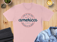 Load image into Gallery viewer, Pink t-shirt with "Land of the Free Since 1776 America Because of the Brave" text.

