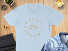 Load image into Gallery viewer, Light blue t-shirt with "1776" and stars design.
