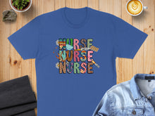 Load image into Gallery viewer, Blue t-shirt with "Nurse" in colorful, patterned block letters and medical icons.
