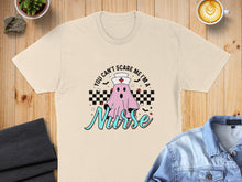 Load image into Gallery viewer, Cream t-shirt with "You can't scare me I'm a Nurse" Halloween ghost graphic.
