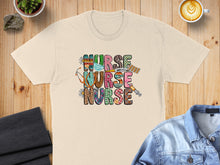 Load image into Gallery viewer, Nurse nurse graphic with stethoscope and medical supplies on t-shirt.
