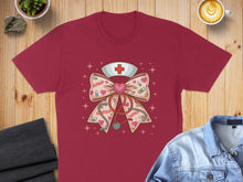 Load image into Gallery viewer, Maroon t-shirt with pink bow, stethoscope, and "XOXO" nurse graphic.
