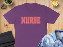 Load image into Gallery viewer, Purple t-shirt with "NURSE" in coral lettering, laid flat with coffee and denim jacket.
