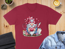 Load image into Gallery viewer, Burgundy t-shirt featuring a gnome nurse with a stethoscope, heart, and medical supplies.
