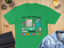 Load image into Gallery viewer, Green t-shirt with medical graphics and text: "Can't talk right now, doing nurse stuff".
