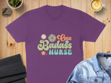 Load image into Gallery viewer, Purple t-shirt with "One Badass Nurse" floral text design.
