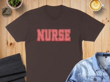 Load image into Gallery viewer, Brown t-shirt with pink "NURSE" graphic, denim jacket, and coffee.
