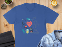 Load image into Gallery viewer, Blue t-shirt with stethoscope, heart, syringe, and "She works willingly with her hands" text.
