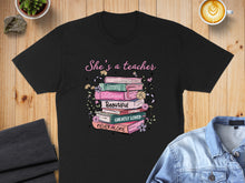 Load image into Gallery viewer, Black t-shirt with stacked books featuring inspirational words for teachers.
